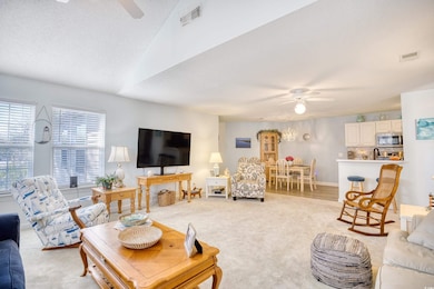Living room featuring light carpet, ceiling fan, a