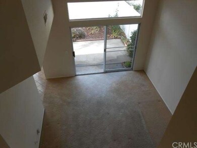 Vaulted ceiling in living room has a view of patio
