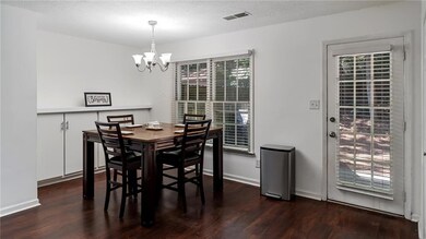 Dining room featuring a chandelier, wood finished floors, and a textured ceiling