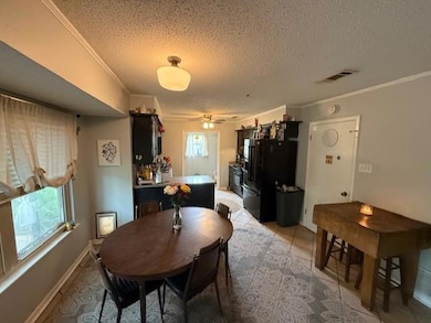 Dining room with ornamental molding, a textured c