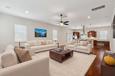 Living area featuring dark wood-style flooring, a ceiling fan, and recessed lighting
