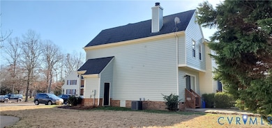 View of property exterior with roof with shingles, a chimney, and a lawn