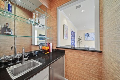 Bar featuring wet bar, a sink, ornamental molding,