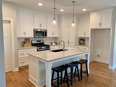 Kitchen features quartz counters in a soft gray