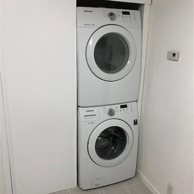 Washroom with stacked washer / dryer, laundry are