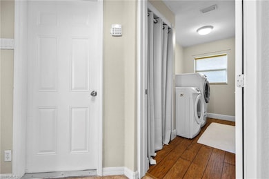 Washroom featuring dark hardwood / wood-style floors and separate washer and dryer