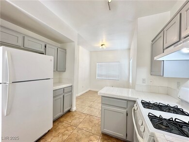 Kitchen featuring white appliances, gray cabinetry