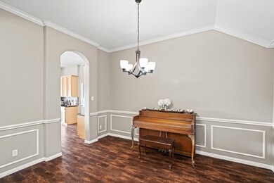 You'll host lavish dinner parties in the spacious formal dining room with gorgeous wood-look tile floors, fresh neutral paint, chair, picture and crown molding, an elegant chandelier, soft natural light and easy access to a dreamy kitchen.