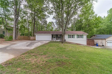 Ranch-style house featuring a garage, a front lawn