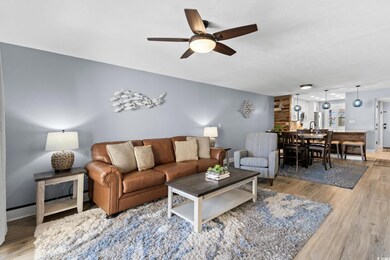 Living room featuring light wood-style flooring and a ceiling fan