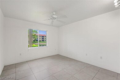 Empty room featuring light tile patterned flooring and ceiling fan