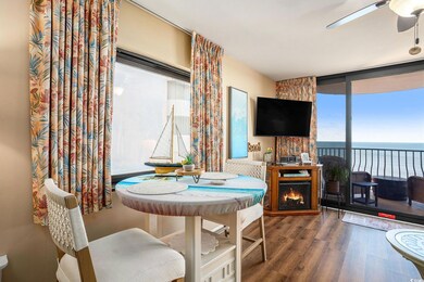 Dining area featuring dark wood-style flooring, ceiling fan, and a wall of windows