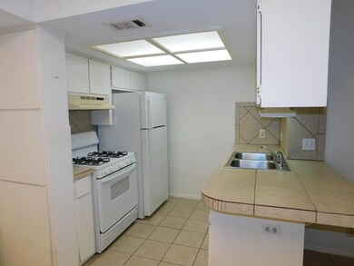 Kitchen featuring a sink, visible vents, under ca