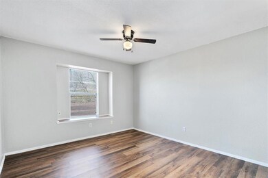 Unfurnished room with dark wood finished floors and ceiling fan