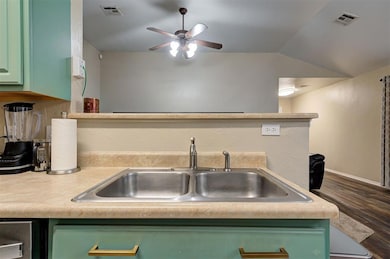 Kitchen featuring vaulted ceiling, green cabinetry