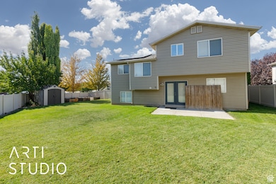 Rear view of house featuring a fenced backyard, a storage unit, french doors, and a patio area