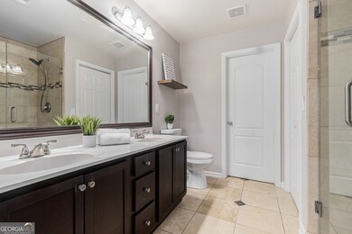 Upstairs, the Oversized Owner's Suite provides a Serene Retreat with Trey Ceilings, a Spa-Inspired Bathroom complete with a Glass Shower and Bench, Double Vanity Sinks, and a Large Walk-In Closet
