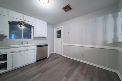 Kitchen featuring dark wood-type flooring, white c