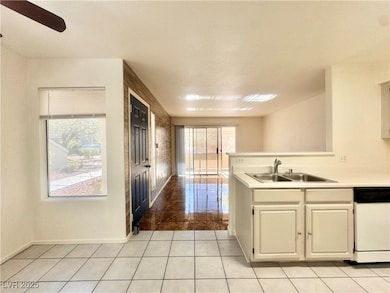 Kitchen featuring a sink, white dishwasher, light