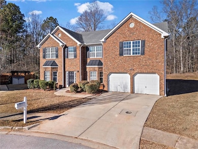 View of front facade featuring brick siding, an attached garage, and driveway