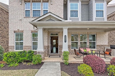 Entrance to property with brick siding, a porch, a
