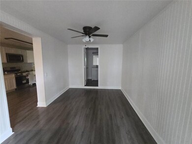 Unfurnished room featuring dark hardwood / wood-style flooring and ceiling fan