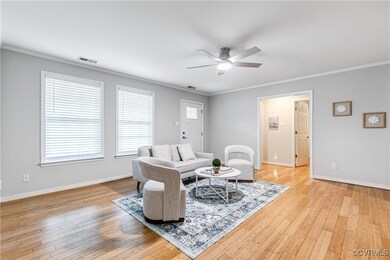 Living room with light hardwood / wood-style flooring, ornamental molding, and ceiling fan