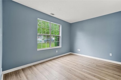 Unfurnished room featuring wood finished floors and a textured ceiling