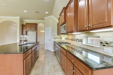 Kitchen with brown cabinetry, decorative backspla