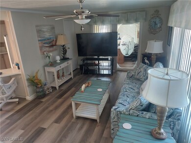 Living room with crown molding, ceiling fan, and w