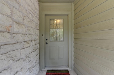 Doorway to property featuring stone siding