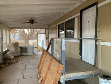 Unfurnished sunroom featuring ceiling fan