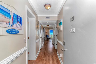 Corridor with a textured ceiling, wood finished fl