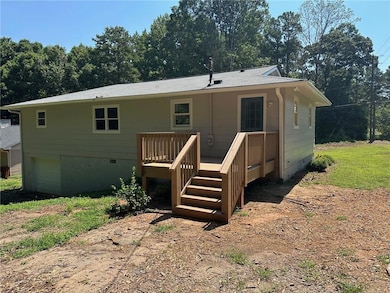 Back of house with a wooden deck and crawl space