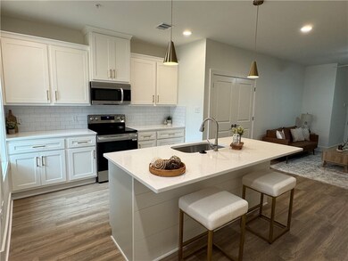 Kitchen featuring white cabinets, a sink, stainles