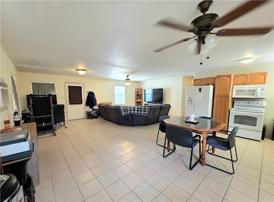 Dining area featuring ceiling fan and light tile p