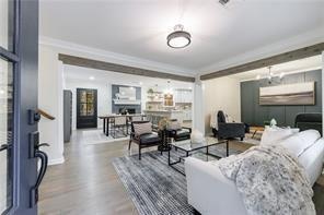 Living area with wood finished floors and ornamental molding