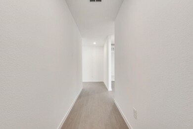 Corridor with wood finished floors and recessed lighting