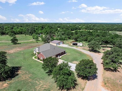 Aerial view of property and surrounding area with a heavily wooded area