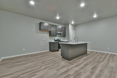 Unfurnished living room featuring light wood-style flooring, baseboards, a sink, and recessed lighting