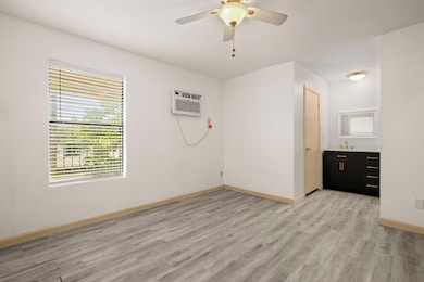 Empty room featuring ceiling fan, light wood-styl