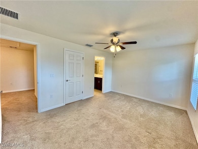 Unfurnished bedroom featuring baseboards, visible vents, and light colored carpet