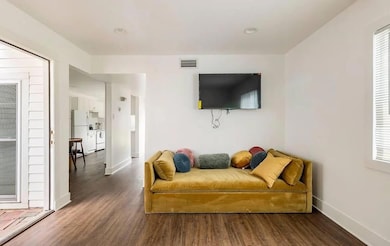 Sitting room with wood finished floors and basebo