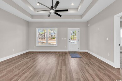 Entryway featuring baseboards, a tray ceiling, woo