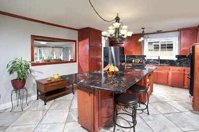 The chef in the family is going to truly appreciate the expansive remodeled family kitchen with its designer lighting, rich wood-grained cabinetry that reaches the ceiling, crown molding, handy pantry, durable dual basin stainless steel  sink, granit