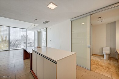 Kitchen featuring floor to ceiling windows, modern cabinets, a kitchen island, light tile patterned floors, and open floor plan