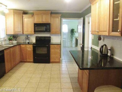 Kitchen. Kitchen has newer kitchen cabinets, granite counter tops, black appliances, tile floors, and note the neat island for eating or working...there is a pantry as well