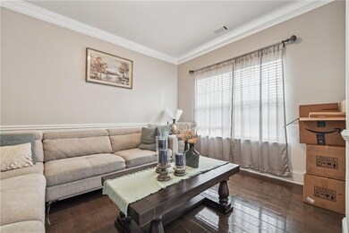 Living room with ornamental molding, dark wood fin