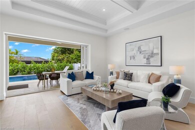 Living room with a tray ceiling and light hardwood