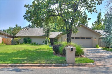 A perfectly manicured front yard, mature trees wit